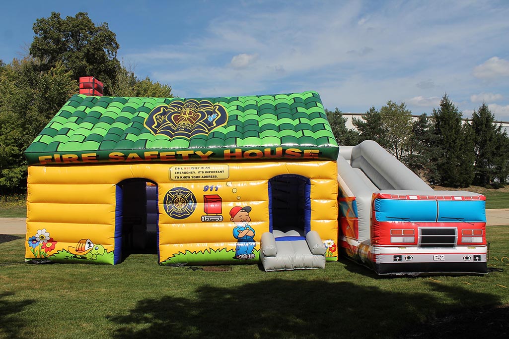 Inflatable fire house with slide